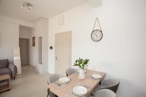 a dining room table with chairs and a clock on the wall at Boka Panoramic in Đenovići