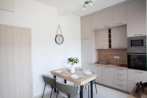 a kitchen with a table with chairs and a clock on the wall at Boka Panoramic in Đenovići