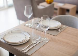a wooden table with plates and wine glasses on it at Boka Panoramic in Đenovići