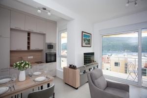 a kitchen with a table and chairs and a large window at Boka Panoramic in Đenovići