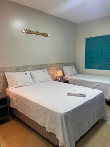 two beds in a room with blue shutters at Voar Pousada in Barreirinhas +19 photos