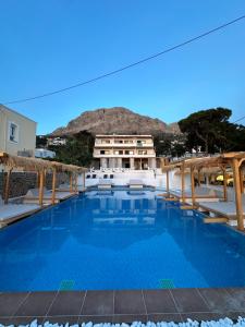 SPONGIA HOTEL AND SUITES في Myrties: مسبح امام مبنى فيه جبل في الخلف