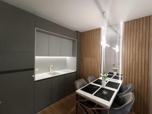 a kitchen with a sink and a table with chairs at Tranquilo Escapes in Sunny Beach