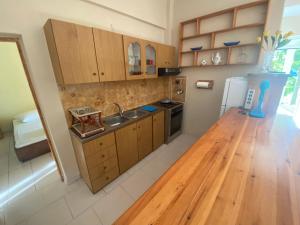 a kitchen with wooden cabinets and a wooden floor at Villa-Litsa in Leptokaria +39 photos