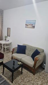 ein Wohnzimmer mit einem Sofa und einem Tisch in der Unterkunft Furnished bedroom near Abu Dhabi Corniche in Abu Dhabi