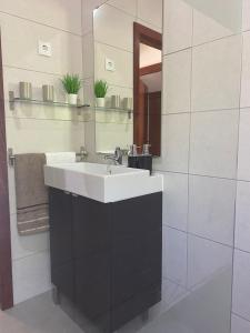 a bathroom with a white sink and a mirror at Casa do Rio in Freixo de Espada à Cinta +14 photos