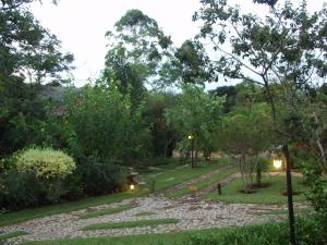 a garden with a pathway and trees and lights at Pousada Spa Prana Lorien in Santo Antônio do Leite