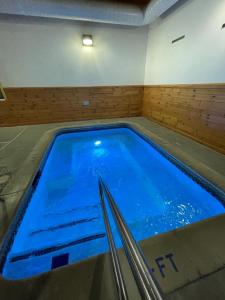Una piscina con agua azul en una habitación. en Ausable Valley Inn, en Mio