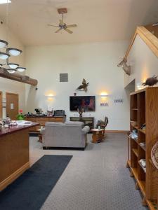 Una sala de estar con un sofá y un televisor. en Ausable Valley Inn, en Mio