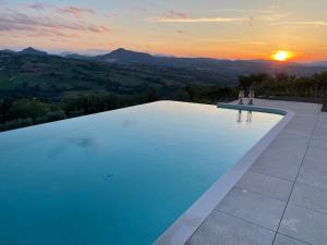 einen Pool mit Sonnenuntergang im Hintergrund in der Unterkunft Casa Ripa Guest House in Cupramontana