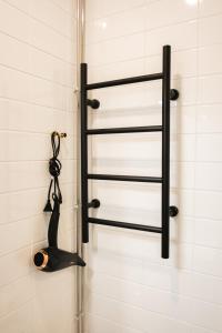 a shower with black towel racks in a bathroom at Cozy and stylish studio in Kamppi in Helsinki