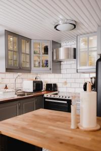 a kitchen with gray cabinets and a wooden counter top at Cozy and stylish studio in Kamppi in Helsinki