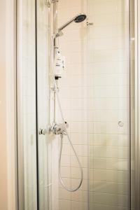 a shower with a shower head in a bathroom at Cozy and stylish studio in Kamppi in Helsinki