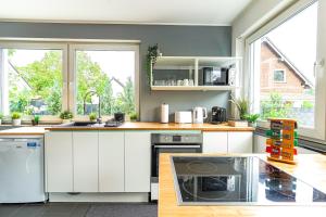 cocina con armarios blancos y ventana grande en Apartment Köln en Colonia