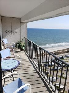 a balcony with a table and chairs and the beach at Myrtle Beach Resort RT1812 in Myrtle Beach