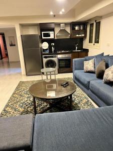 ein Wohnzimmer mit einem blauen Sofa und einem Tisch in der Unterkunft بورتو السخنه -Hotel Porto vib in Ain Suchna