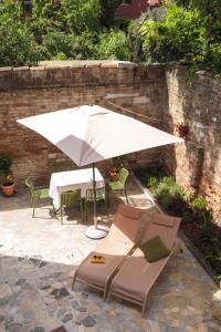 a white umbrella and some chairs and a table at Giselda Courtyard Retreat in Venice