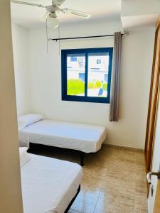 モハカルにあるApartamento Perla Playaの窓のある部屋にベッドが2つある +10枚の写真