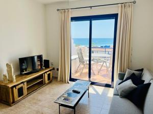 モハカルにあるApartamento Perla Playaのリビングルーム(ソファ、テレビ、バルコニー付)