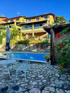 a patio with a table and chairs and a building at Casa Cantinho da Paz, seu lazer completo, churrasqueira, piscina e muita tranquilidade in Gravatá