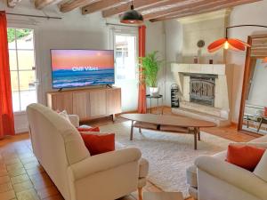 a living room with a tv and a fireplace at Le Haut Bois - à 5min du Zoo et centre-ville in Saint-Aignan