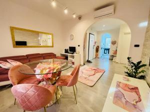 a living room with a glass table and pink chairs at Lady Hana in Marghera