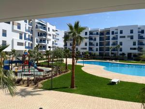 a view of a resort with a playground and a pool at Costa Mar, Playa 5 in Martil