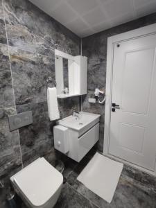 a bathroom with a toilet and a sink and a door at The Brothers Suite Dalaman in Dalaman
