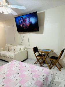 lovely apartment with free parking في ميامي: غرفة معيشة مع أريكة وتلفزيون على الحائط