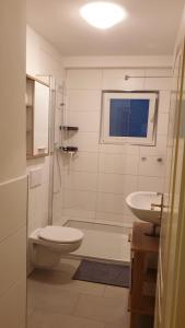 uma casa de banho branca com um WC e um lavatório em 3-Zimmer mitten in Siegburg em Siegburg