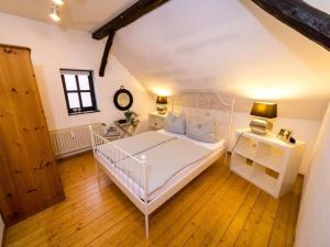 ein Schlafzimmer mit einem weißen Bett und zwei Nachttischen in der Unterkunft Attractive apartment in Katzweiler in Brakel