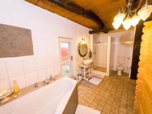 ein großes Bad mit einer Badewanne und einem WC in der Unterkunft Attractive apartment in Katzweiler in Brakel