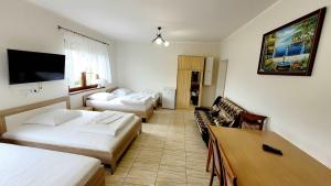 um quarto de hotel com duas camas e um sofá em Gościniec Krys em Znin