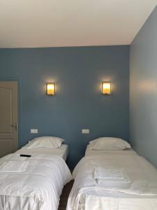 Résidences saint pierre في لورد: سريرين في غرفة بجدران زرقاء