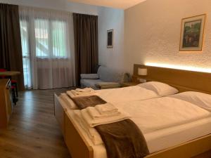 una camera d'albergo con letto e divano di Hotel San Lorenzo a San Lorenzo in Banale