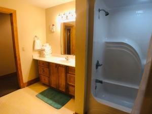 a bathroom with a tub and a sink and a shower at Briarstone Lodge Condo 13B by Eden Crest in Pigeon Forge +20 photos