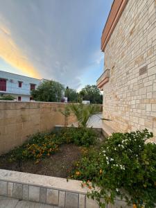 Baia VerdeにあるI love Baia Verde & spaのレンガ造りの建物の隣にある花の庭園