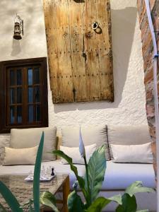 Riad Gharnata في شفشاون: غرفة معيشة مع أريكة وجدار خشبي
