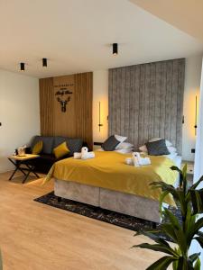 Un dormitorio con una gran cama amarilla y un sofá en Rezydencja Biały Dom en Ustrzyki Dolne