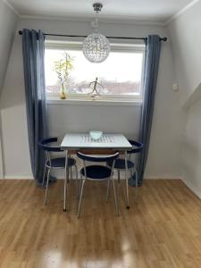 a table and chairs in a room with a window at 43 Oscarsgate The View in Vadsø