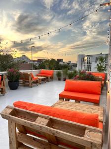 布加勒斯特的住宿－Graffiti Hotel，屋顶露台配有橙色软垫长凳和灯