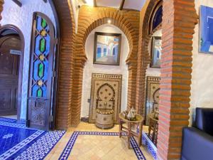 舍夫沙萬的住宿－里亞德戛納塔庭院旅館，一个带游泳池和彩色玻璃的房间的家