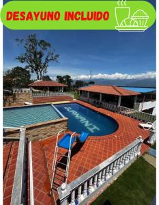 a swimming pool with a red brick patio and a swimming poolvisor at Finca Vacacional Guanani in Socorro