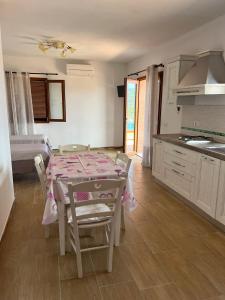 a kitchen and dining room with a table and chairs at Villetta Zuccale II Tranquillità e panorama vicino al mare in Capoliveri