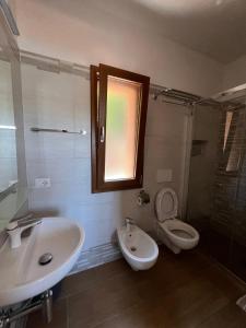 a bathroom with a sink and a toilet and a window at Villetta Zuccale II Tranquillità e panorama vicino al mare in Capoliveri +24 photos