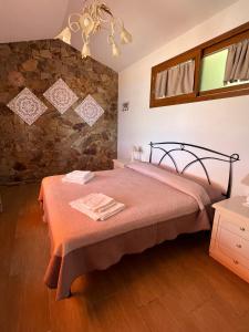 a bedroom with a bed and a stone wall at Villetta Zuccale II Tranquillità e panorama vicino al mare in Capoliveri