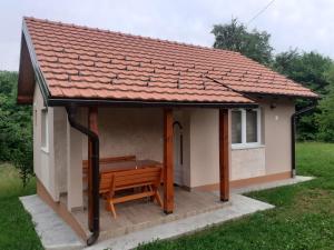 a small house with a bench in front of it at Vikendica Batin Konak in Bajina Bašta