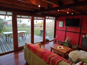 - un salon avec un canapé et une véranda dans l'établissement Green House, à El Calafate