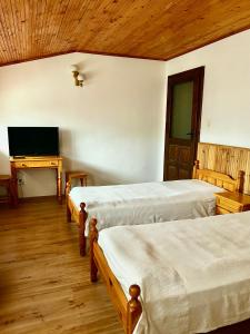Un dormitorio con dos camas y un televisor de pantalla plana. en Torlacite, en Chiprovtsi