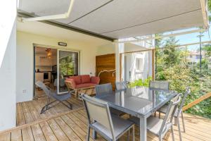 a patio with a table and chairs on a deck at Atlantic Selection - Le Duna - Ambiance zen avec terrasse & parking in Capbreton
